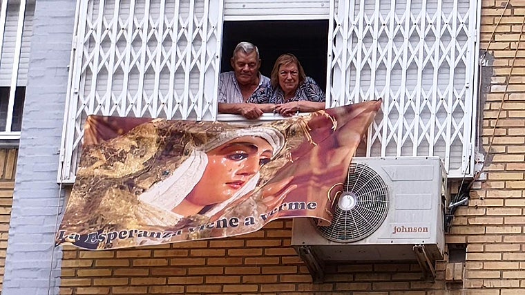 Los padres de Daniel, en su domicilio de La Oliva con una bandera de la Esperanza de Triana