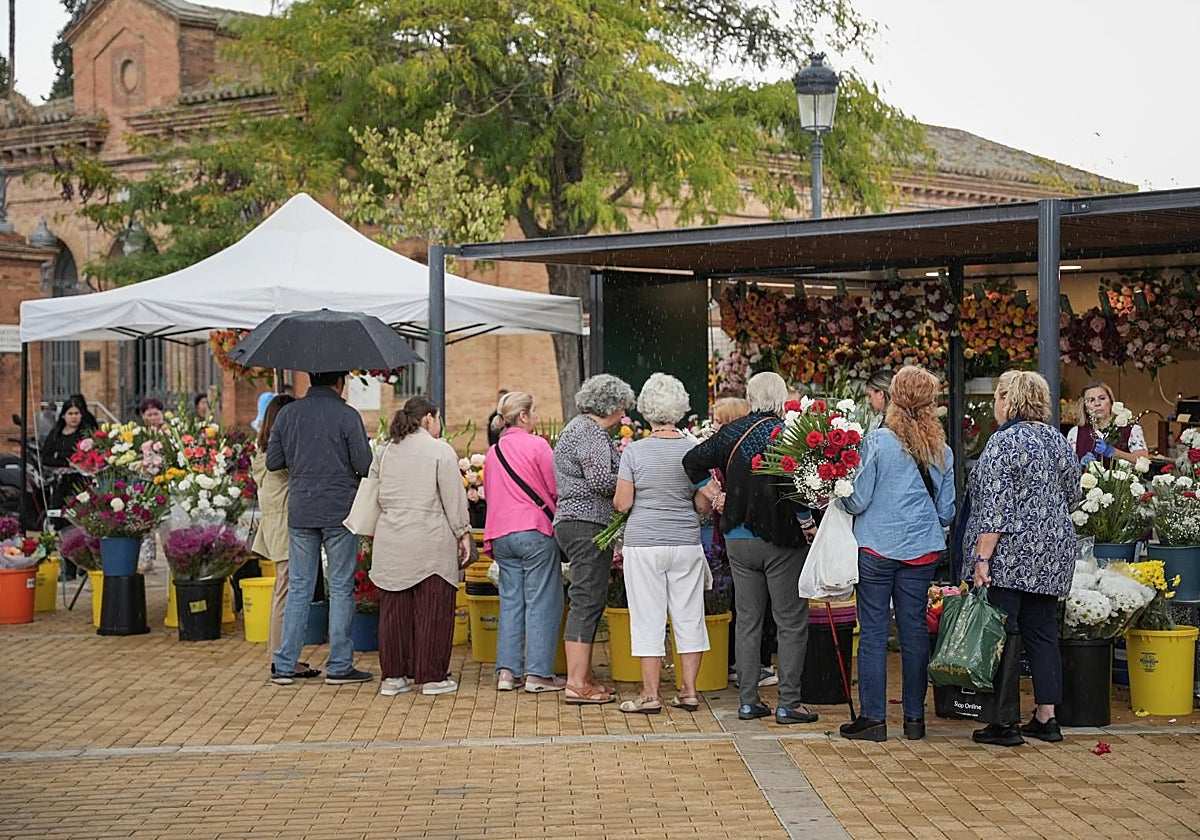 Un grupo de personas compra flores en la entrada del cementerio de San Fernando