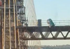 Impactante caída de un aseo portátil en las obras del Puente del Centenario en Sevilla mientras los coches circulan
