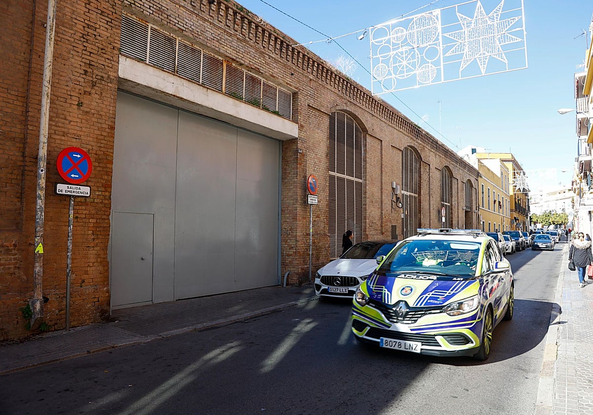 Un coche de la Policía Local de Sevilla junto a la entrada a las Naves de Calatrava