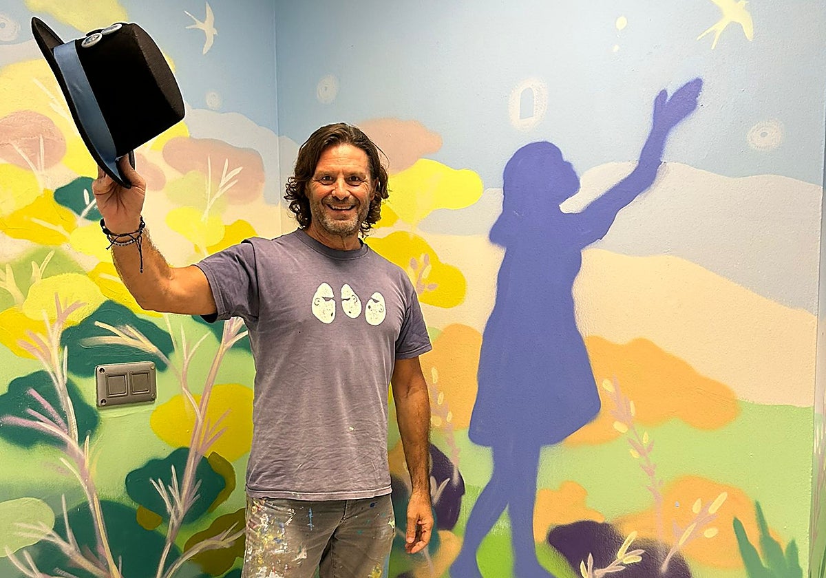 Pepe Yáñez junto una parte del mural que ha pintado en el Hospital Virgen Macarena