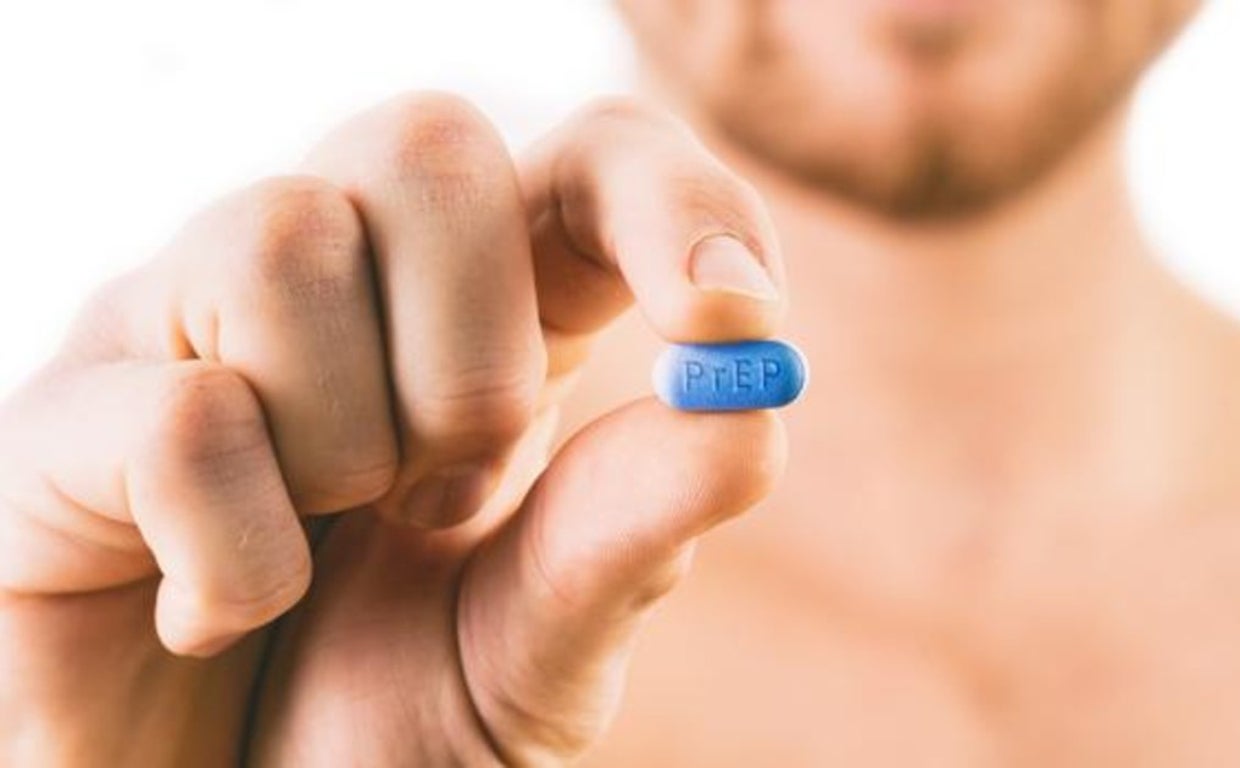 Un hombre sostiene una pastilla de PrEP