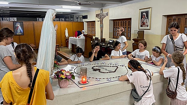 Varios jóvenes españoles rezan y escriben mensajes alrededor de la tumba de la Madre Teresa de Calcuta