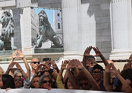 Imagen secundaria 1 - Pancartas y gestos feministas contra la 'ley trans'. A la derecha, la exdiputada del PSOE Ángeles Álvarez asiste a la concentración