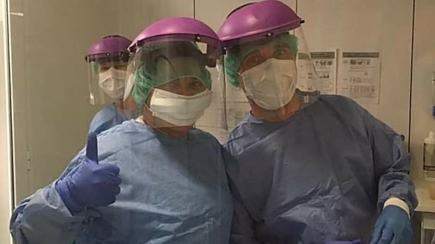 Anuska y un compañero con los trajes de protección individual, en plena pandemia