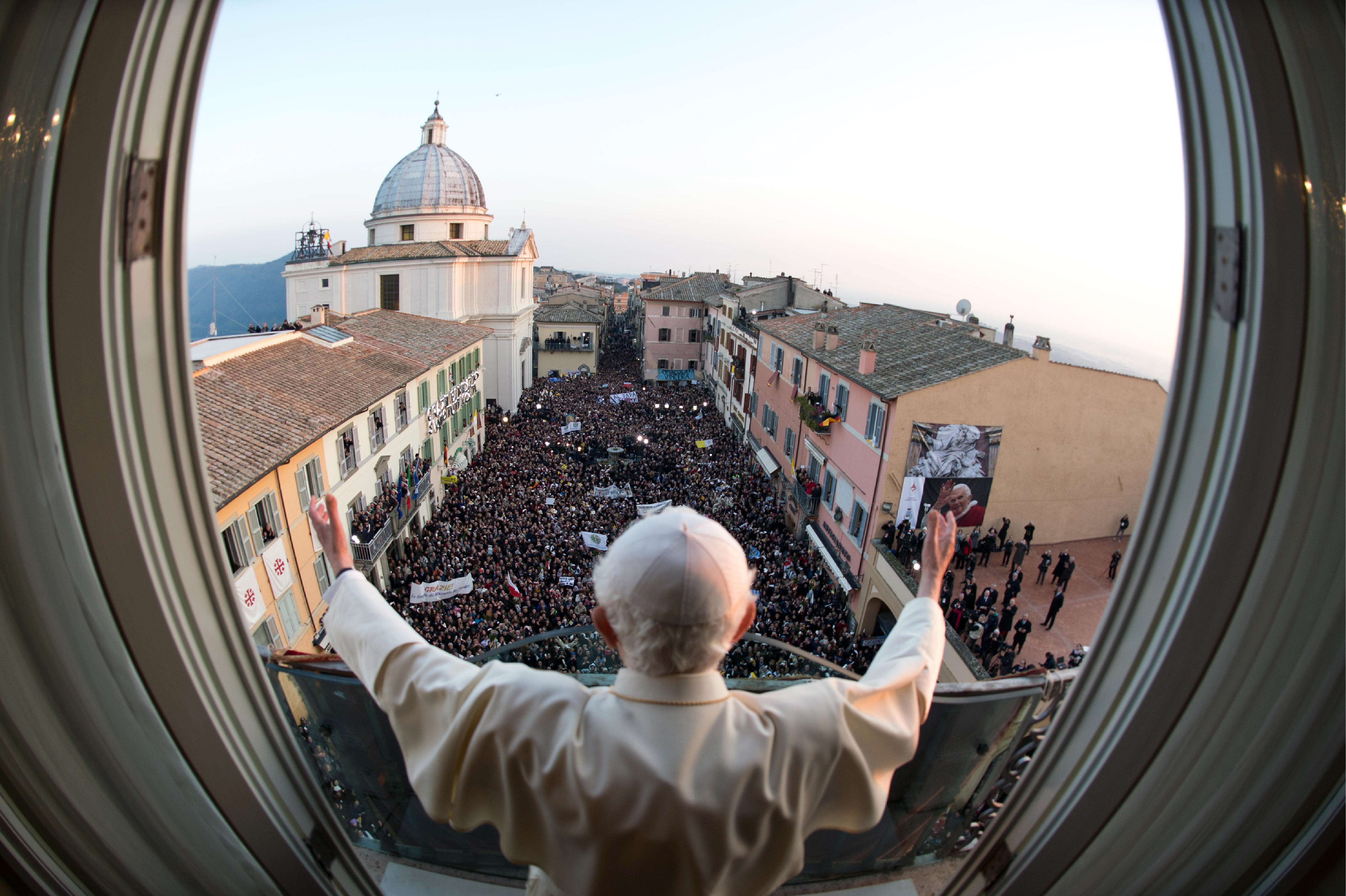 Benedicto XVI bendice a los fieles desde el balcón de su nueva residencia temporal de Castel Gandolfo, cerca de Roma, unas horas antes de renunciar oficialmente en 2013.
