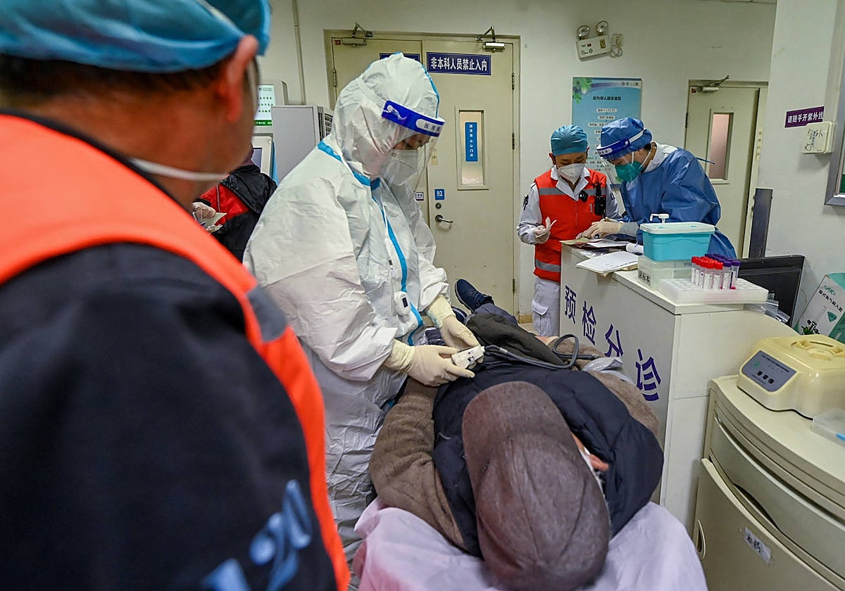 Un médico examina a un paciente en un hospital de Pekín en medio del aumento de casos de Covid