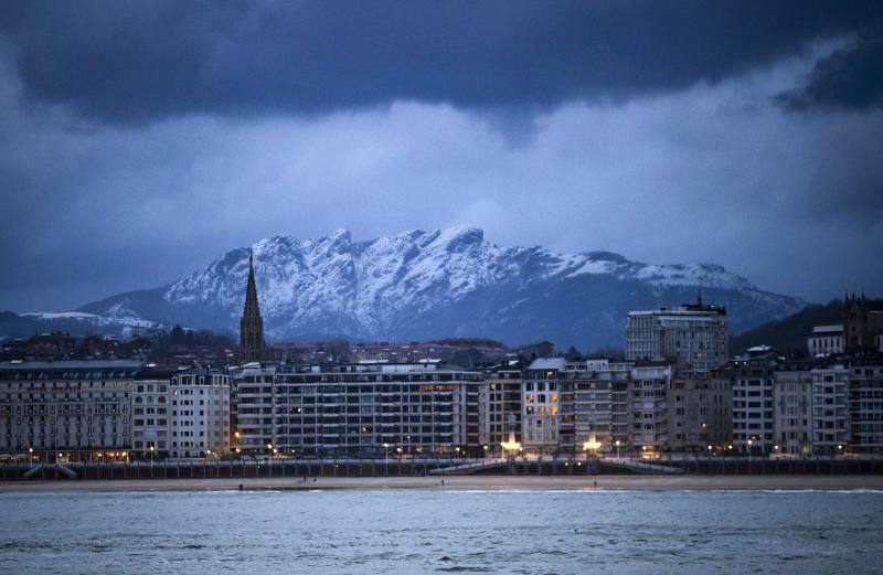 Vista de Peñas de Aia nevado desde la playa de Ondarreta de San Sebastián este miércoles