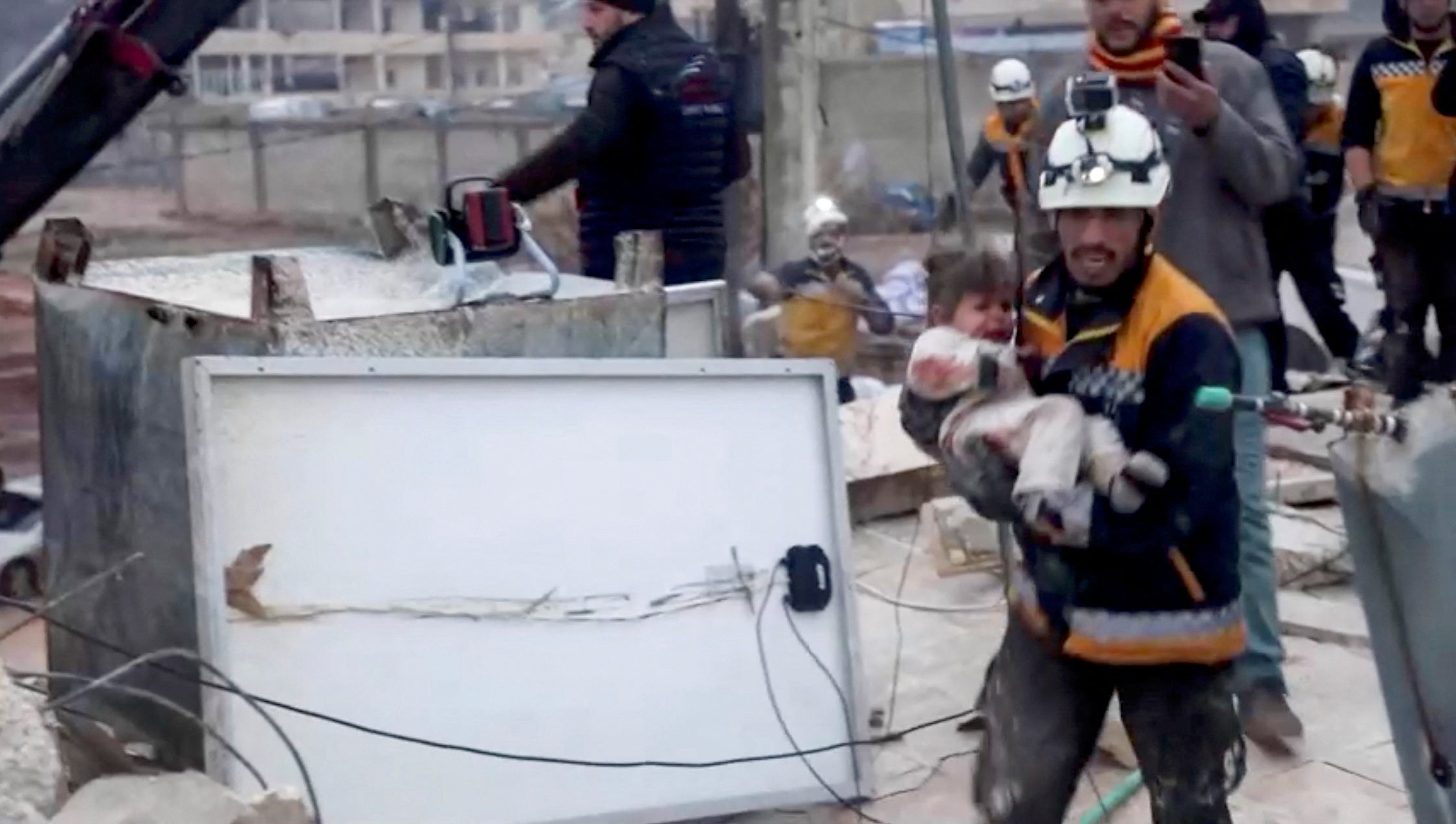 Miembro de las labores de rescate con un niño herido por el terremoto  en Azaz, Siria