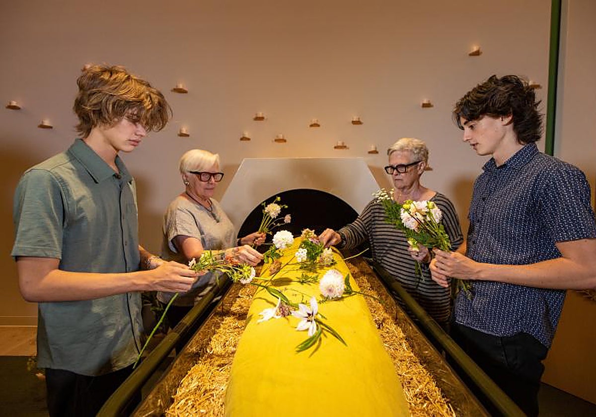Familiares ante un féretro con paja de Recompose, antes de convertir el cuerpo en compost