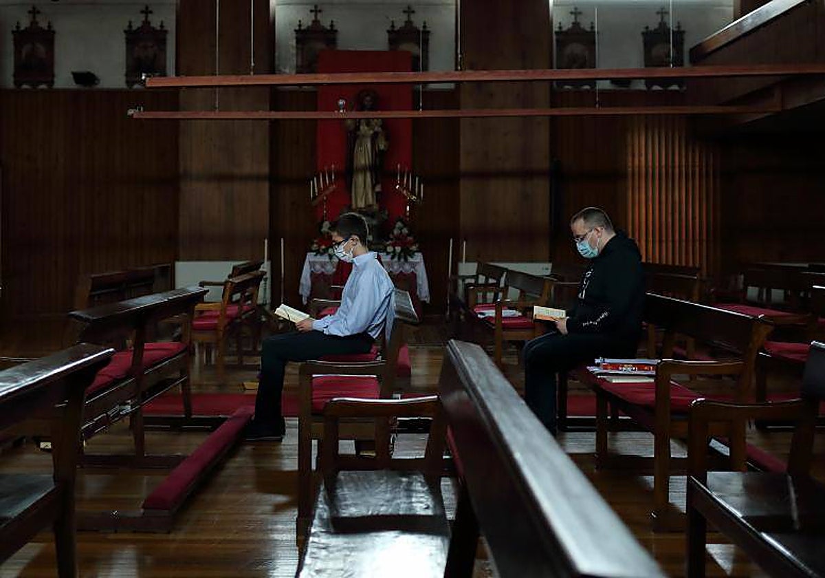 Dos jóvenes rezan en la capilla del seminario de Santiago de Compostela en junio de 2021