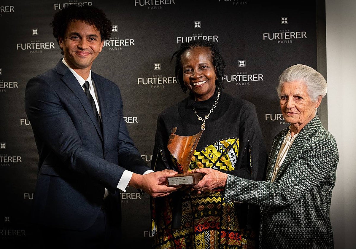 Nicolás Zambré, a la izquierda, y Teresa de Borbón-Dos Sicilias hacen entrega del premio a Florence Oloo, en el centro