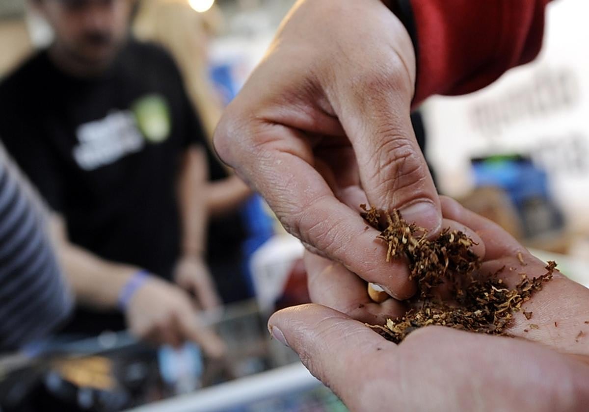 Un hombre lía un cigarrillo de marihuana en una feria celebrada en Madrid