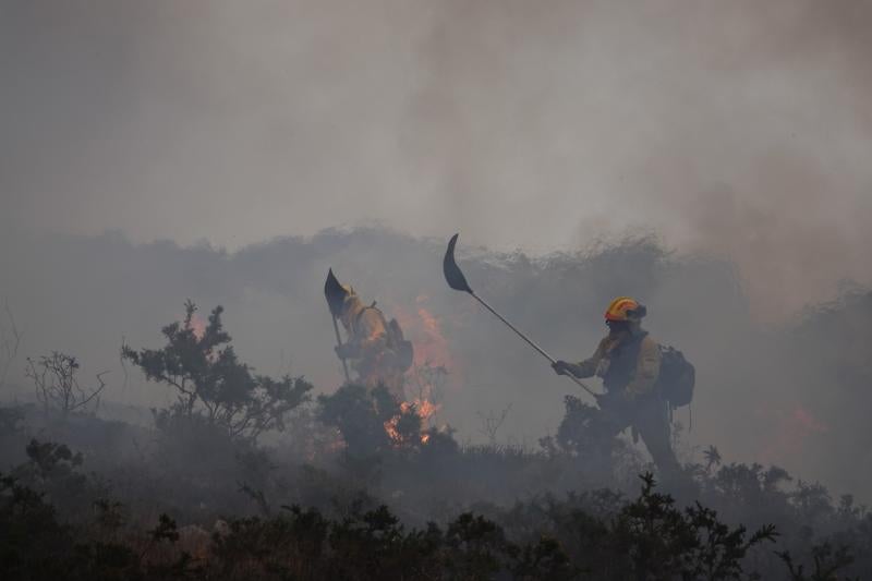 Los bomberos no solo recurren al agua también usan palas para mitigar las llamas
