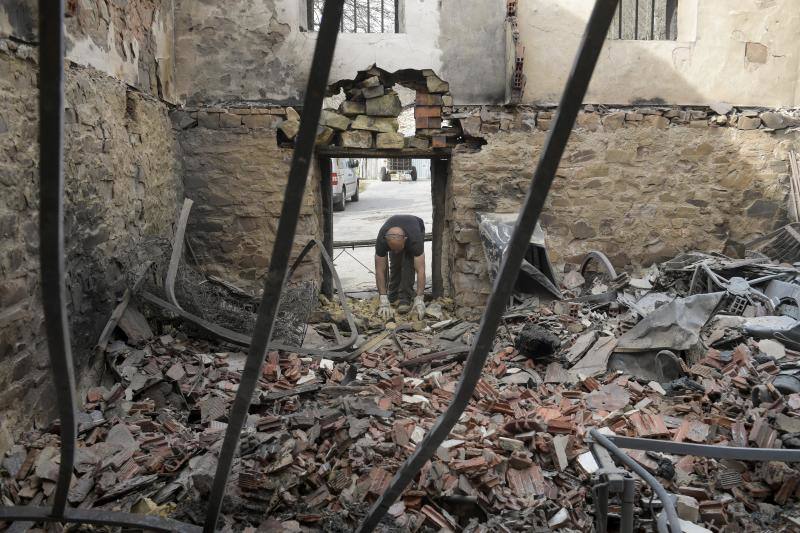 Un hombre junto a los restos calcinados de la vivienda de sus padres en Asturias debido al Incendio declarado en Navelgas