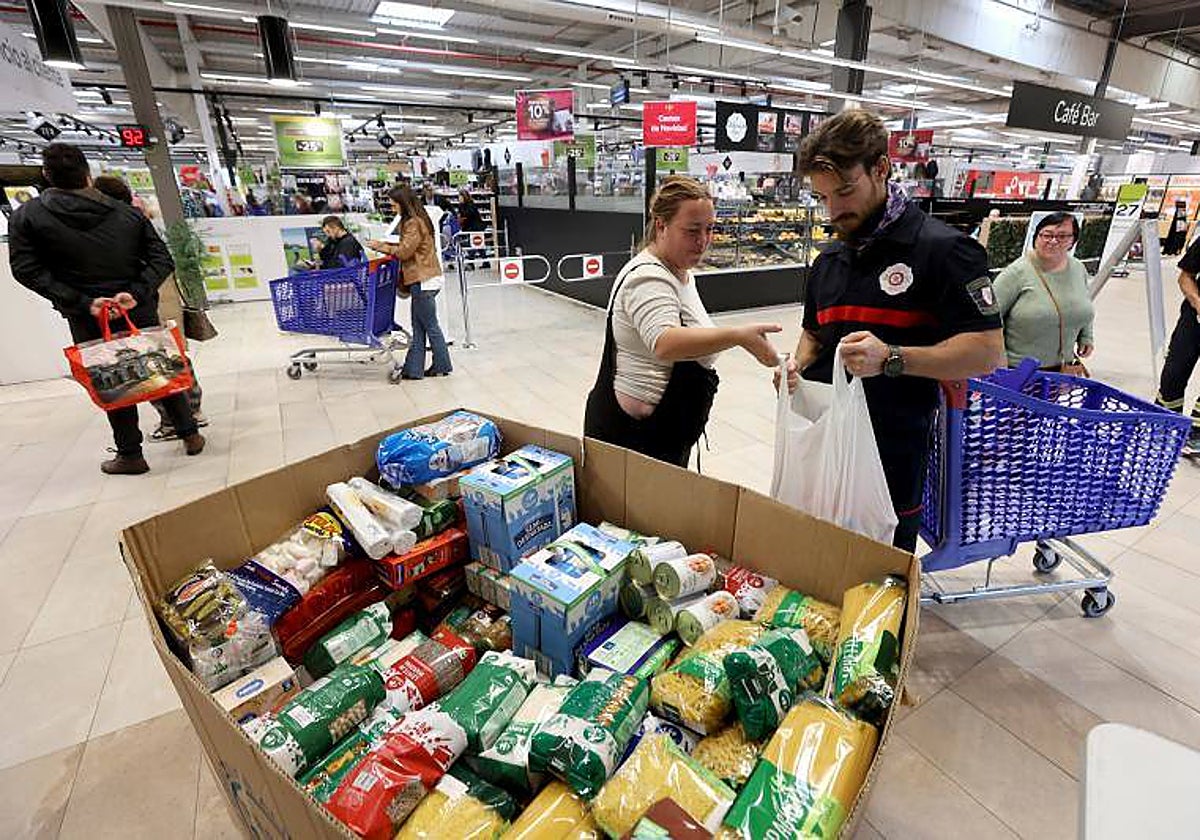 Unos voluntarios reciben donaciones de alimentos a la puerta de un supermercado en Córdoba, en la Gran Recogida de 2022