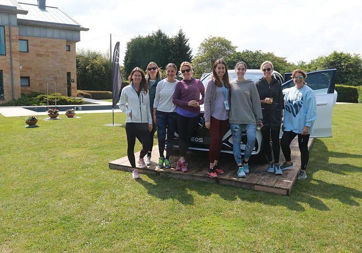Inés Müller y Elena Steiner (Mercedes-Benz) y Samary Fernández Feito (Vocento), junto a un grupo de asistentes al evento posando junto al modelo EQS SUV