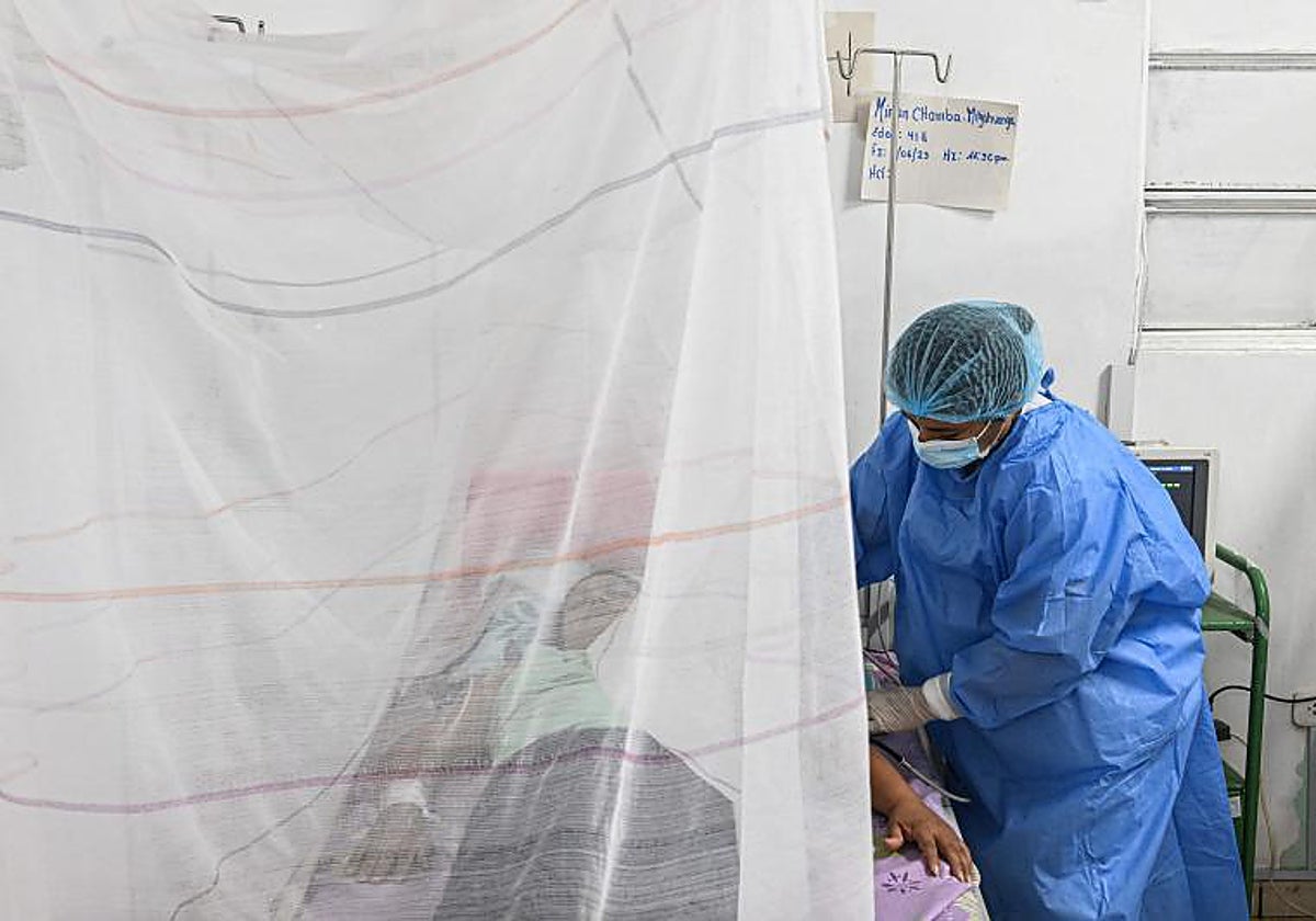 Enfermera junto a una infectada de Dengue en un hospital del norte de Perú