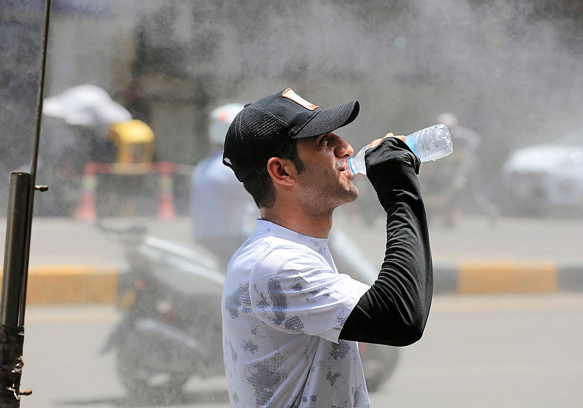 Un hombre mientras bebe agua en un día caluroso