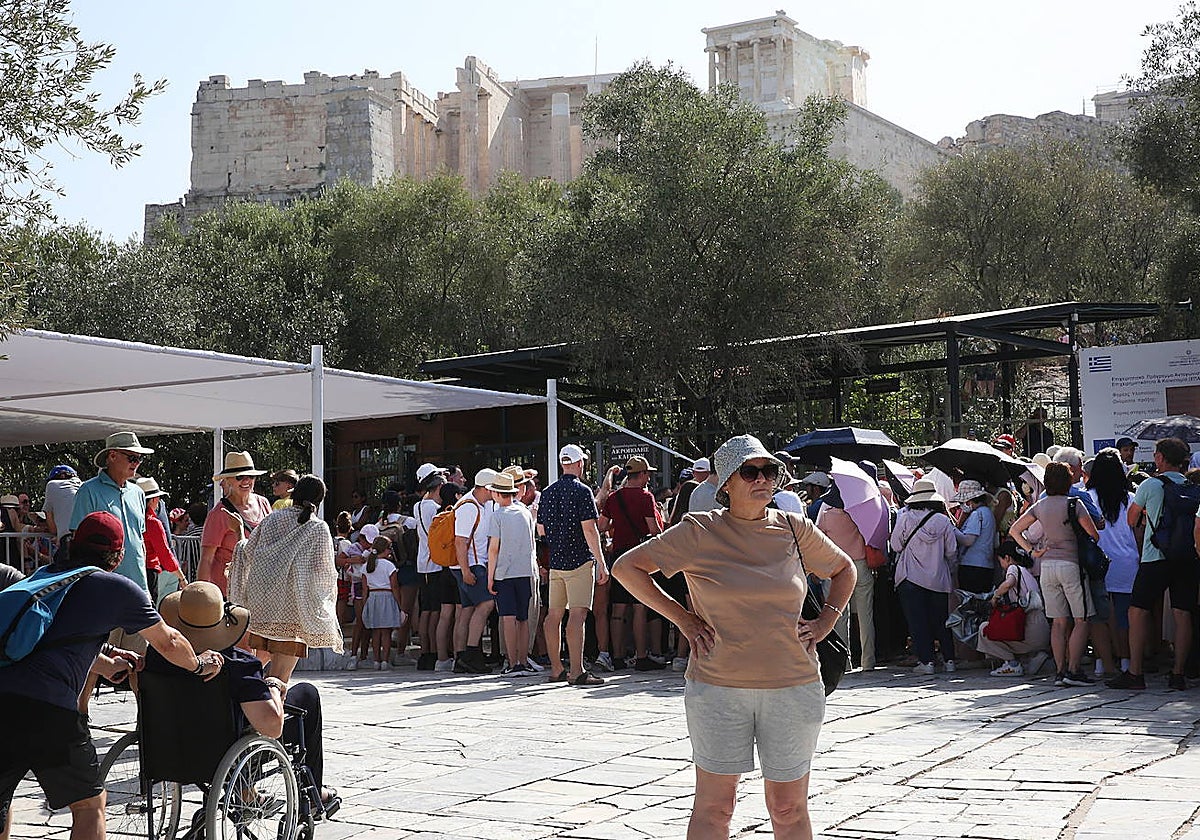 Los turistas esperan en una larga fila para visitar la Acrópolis en medio de altas temperaturas