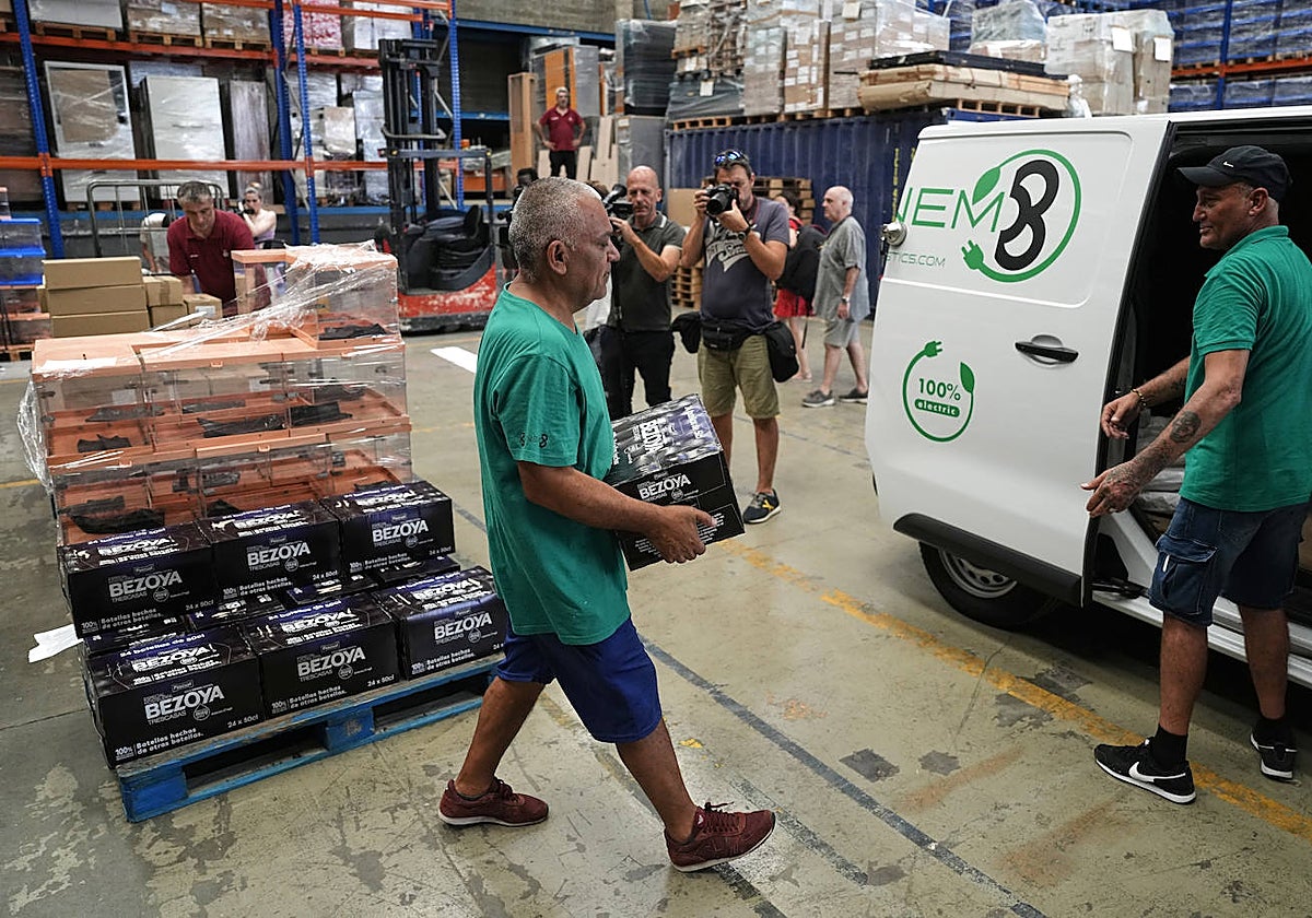 Un operario traslada botellas de agua y urnas para el 23J