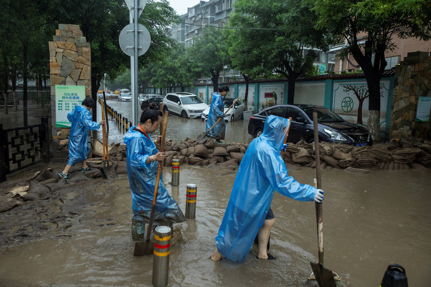 Trabajadores en una de las calles inundadas de Pekín debido al tifón Doksuri