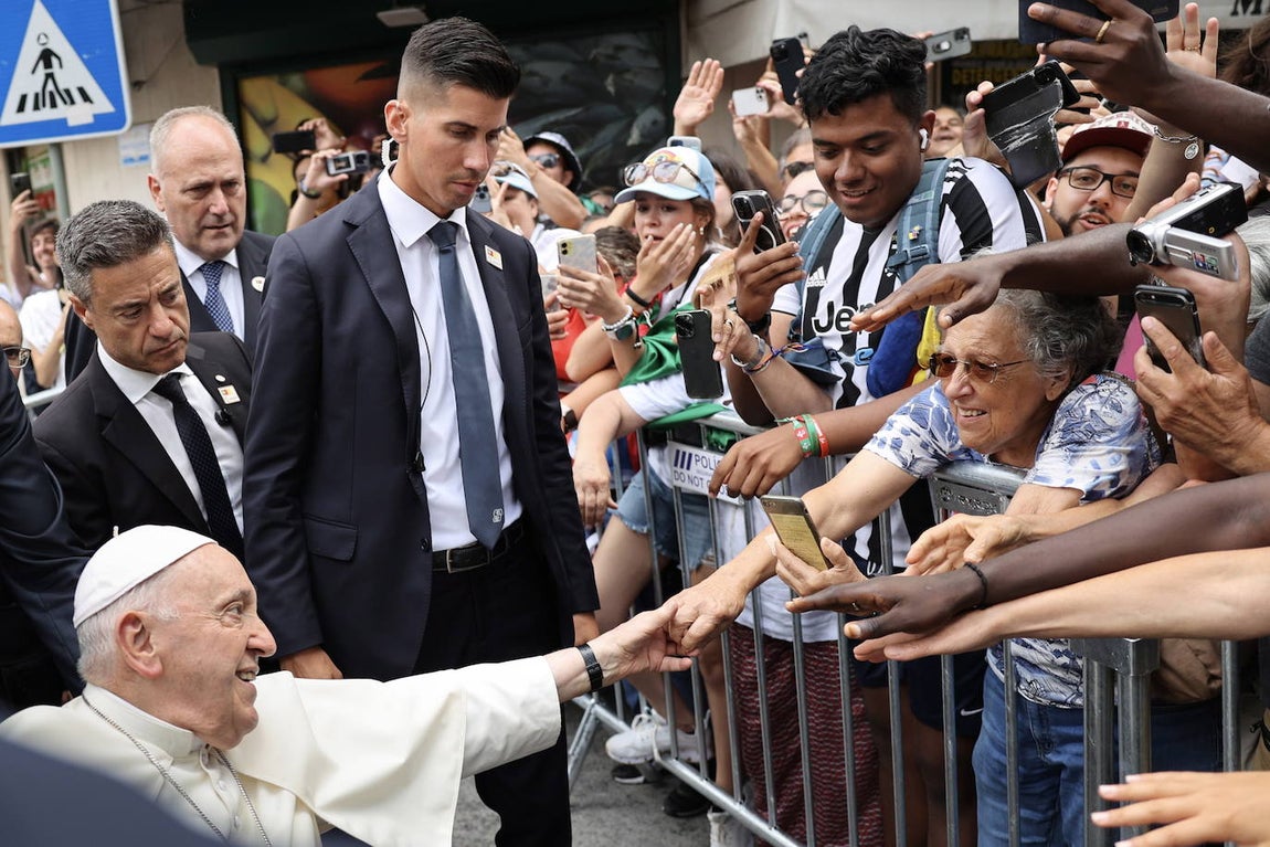 El Papa Francisco saluda a la multitud en Lisboa, los de la primera fila extienden sus brazos para buscar el saludo del Pontífice