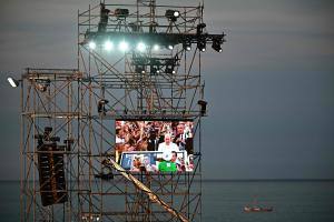 Una pantalla gigante muestra la llegada del Papa Francisco al Parque Tejo para participar en la JMJ 2023.