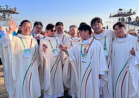 Imagen secundaria 1 - Arriba, unos jóvenes coreanos reciben con alborozo la designación de Seúl como nueva sede para la Jornada Mundial de la Juventud. Debajo a la izquierda, un grupo de sacerdotes coreanos se preparan para celebrar la eucaristía. A la derecha, un peregrino acude al evento ataviado con el traje tradicional coreano.