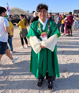 Imagen secundaria 2 - Arriba, unos jóvenes coreanos reciben con alborozo la designación de Seúl como nueva sede para la Jornada Mundial de la Juventud. Debajo a la izquierda, un grupo de sacerdotes coreanos se preparan para celebrar la eucaristía. A la derecha, un peregrino acude al evento ataviado con el traje tradicional coreano.