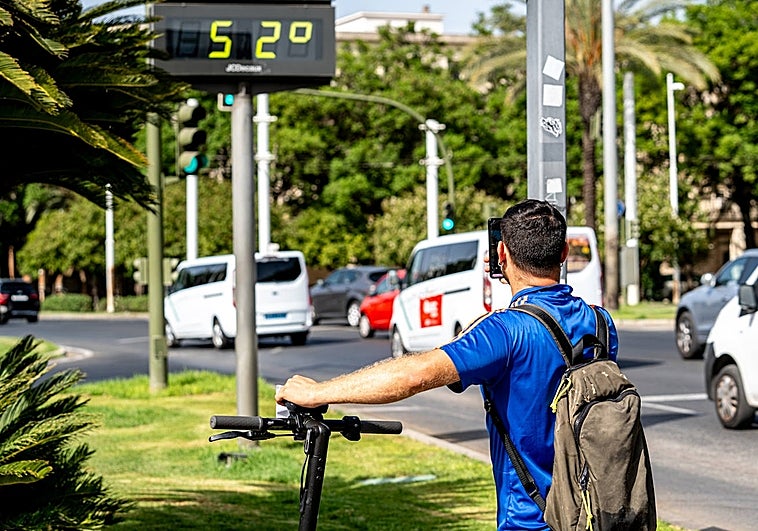 Un turista fotografía un termómetro que marca 52 grados en Sevilla