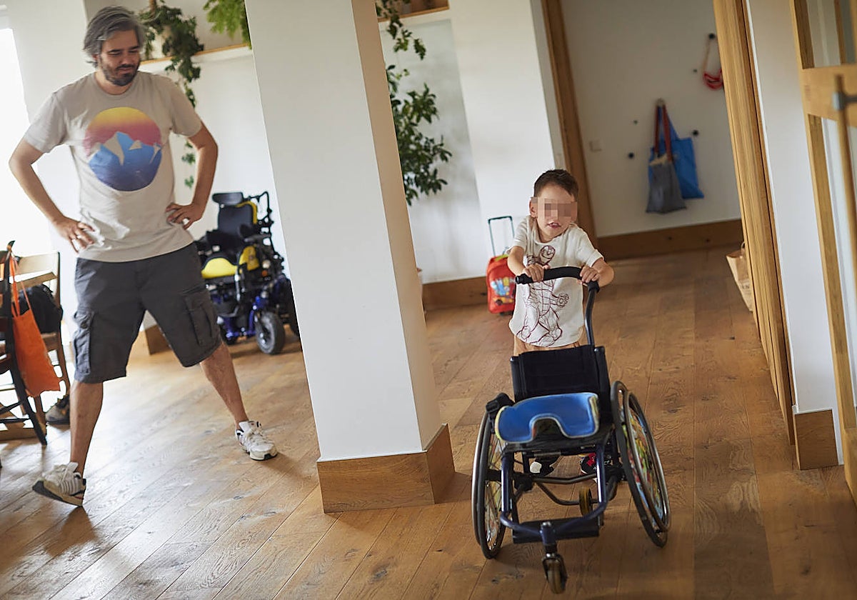 Gael camina agarrado a su silla ante la mirada de su padre, Rodrigo