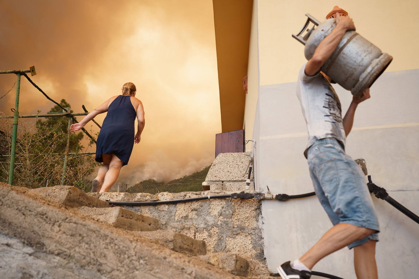 Vecinos de la zona del barrio de Los Margenes, en el pueblo de Igueste de Candelaria, evacuan los enseres de sus viviendas tras el aviso de desalojo