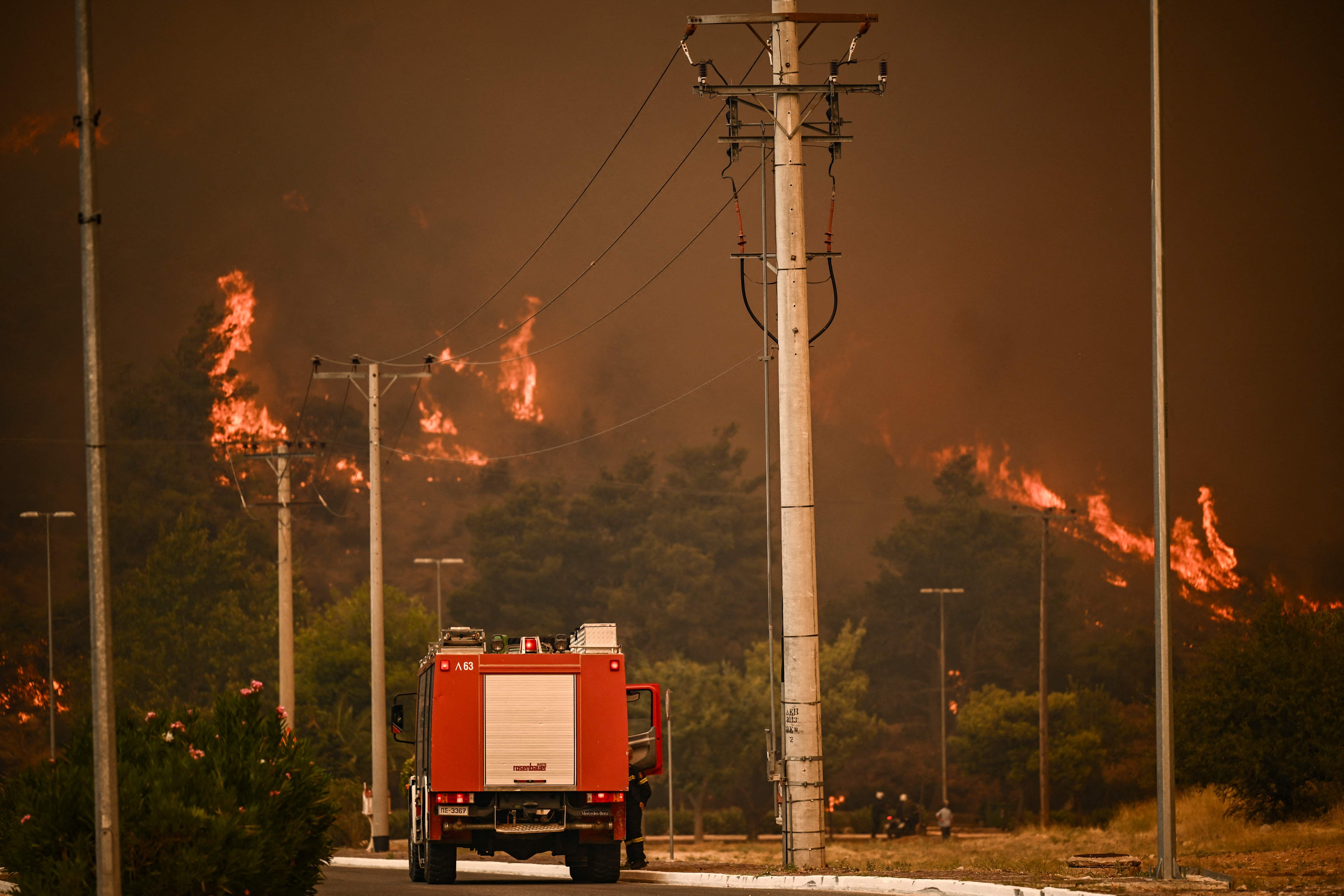 Un camión de bomberos circula por una carretera durante un incendio en Chasia, a las afueras de Atenas 