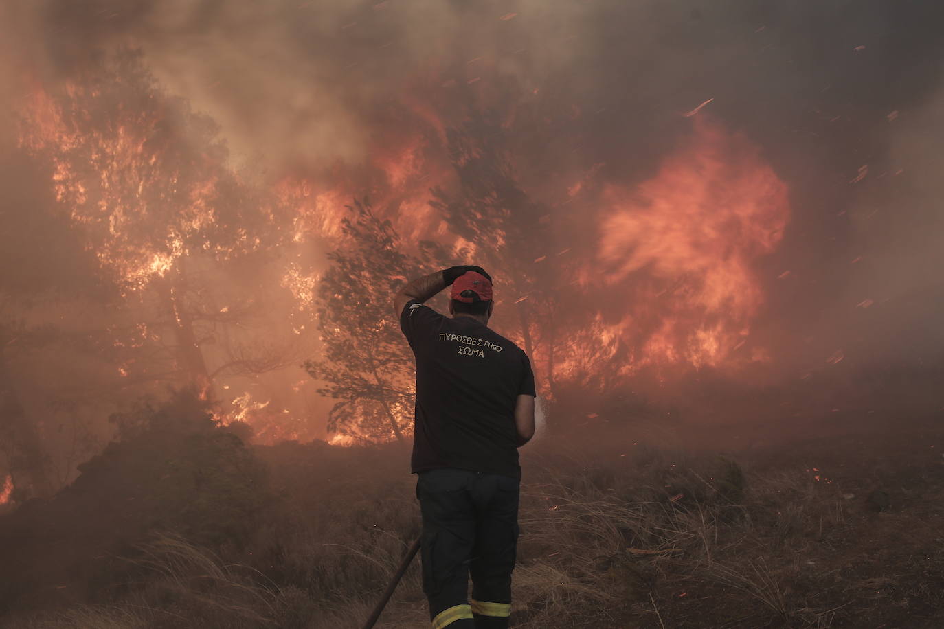 Un bombero reacciona mientras lucha contra las llamas de un incendio forestal en la zona de Fyli, cerca de Atenas (Grecia)