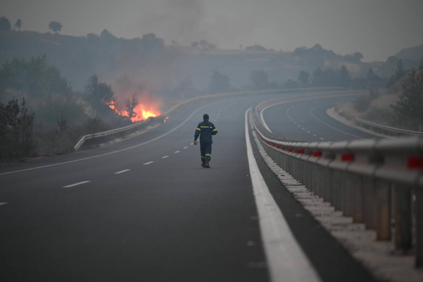 Un bombero camina hacia un incendio en una zona de Alejandrópolis