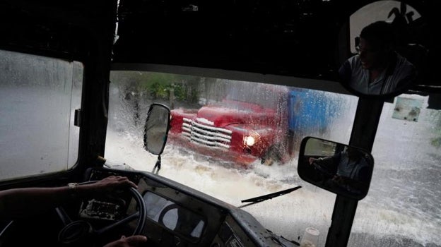 Un autobús pasa por una calle inundada por la tormenta Idalia en Cuba