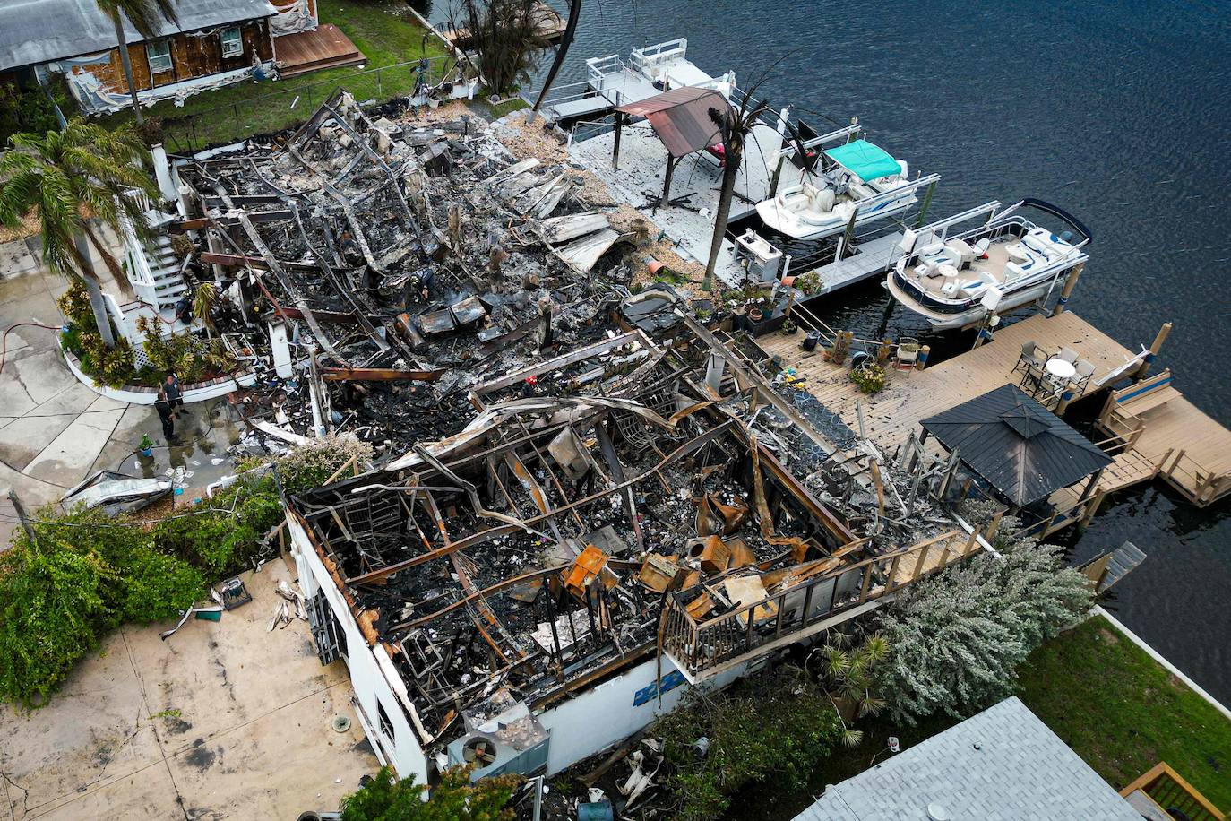 Vista aérea de los escombros quemados donde estaba una casa tras la explosión de un transformador eléctrico en la comunidad de Signal Cove en Hudson, Florida