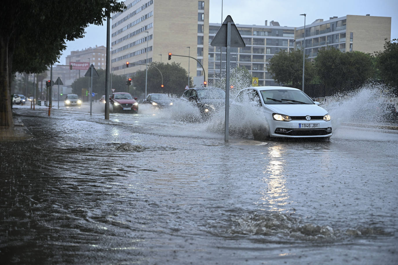 Varios vehículos transitan por la avenida Casalduch parcialmente inundada este sábado en Castellón de la Plana