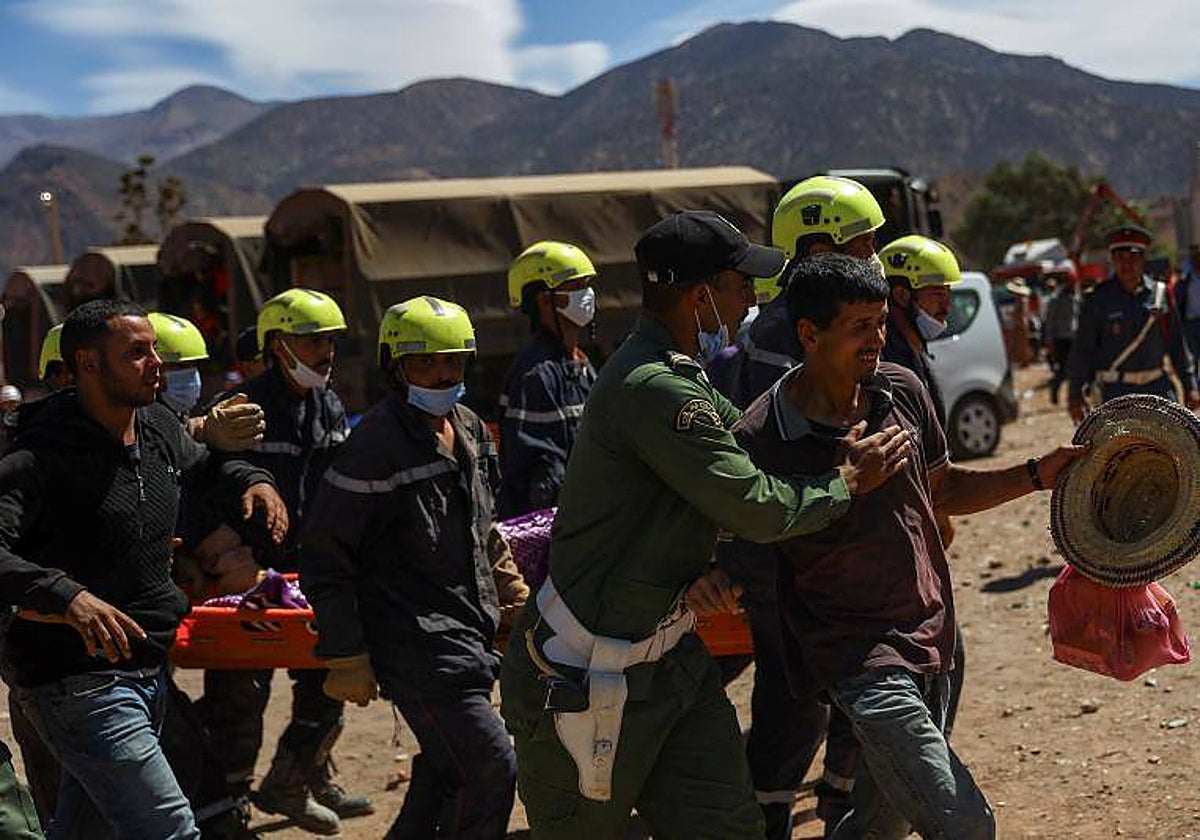 Un hombre llora mientras los equipos de rescate transportan el cadáver de una víctima del terremoto en Talat N'yaaqoub, Marruecos