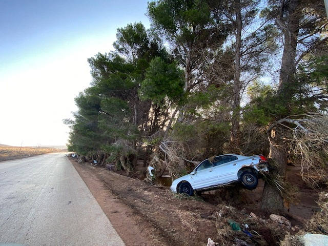 Un coche dañado en una carretera por el paso de la tormenta Daniel