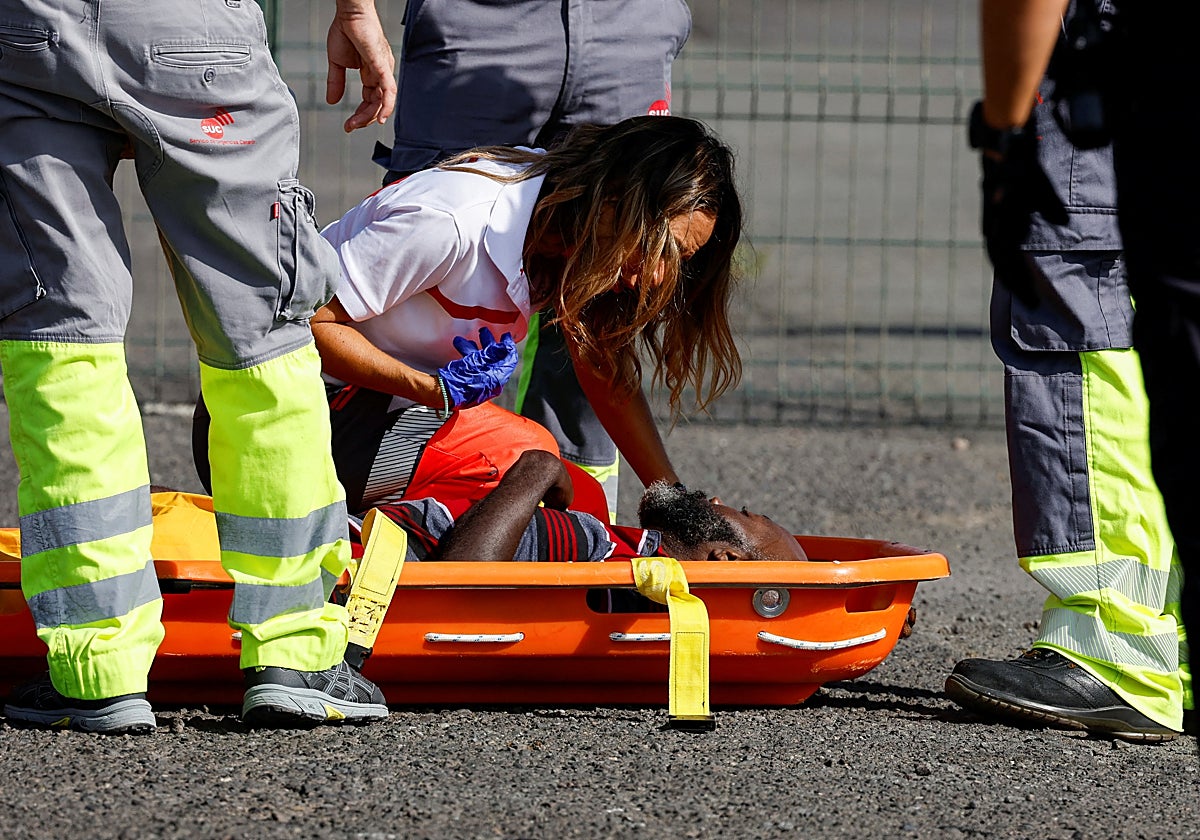 Una enfermera asiste a un inmigrante que llega exhausto a Arguineguín (Gran Canaria). En vídeo, testimonio de Igor Santiago, migrante brasileño.