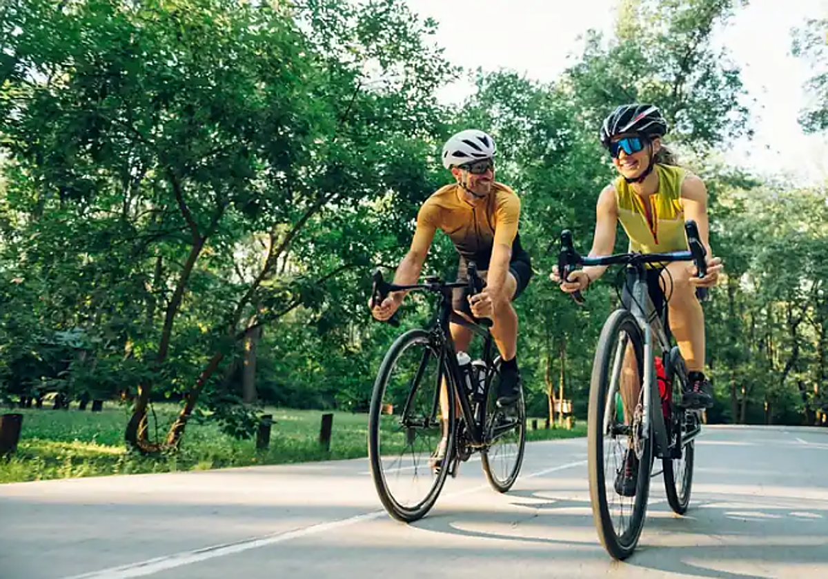 Una pareja monta en bici en un parque