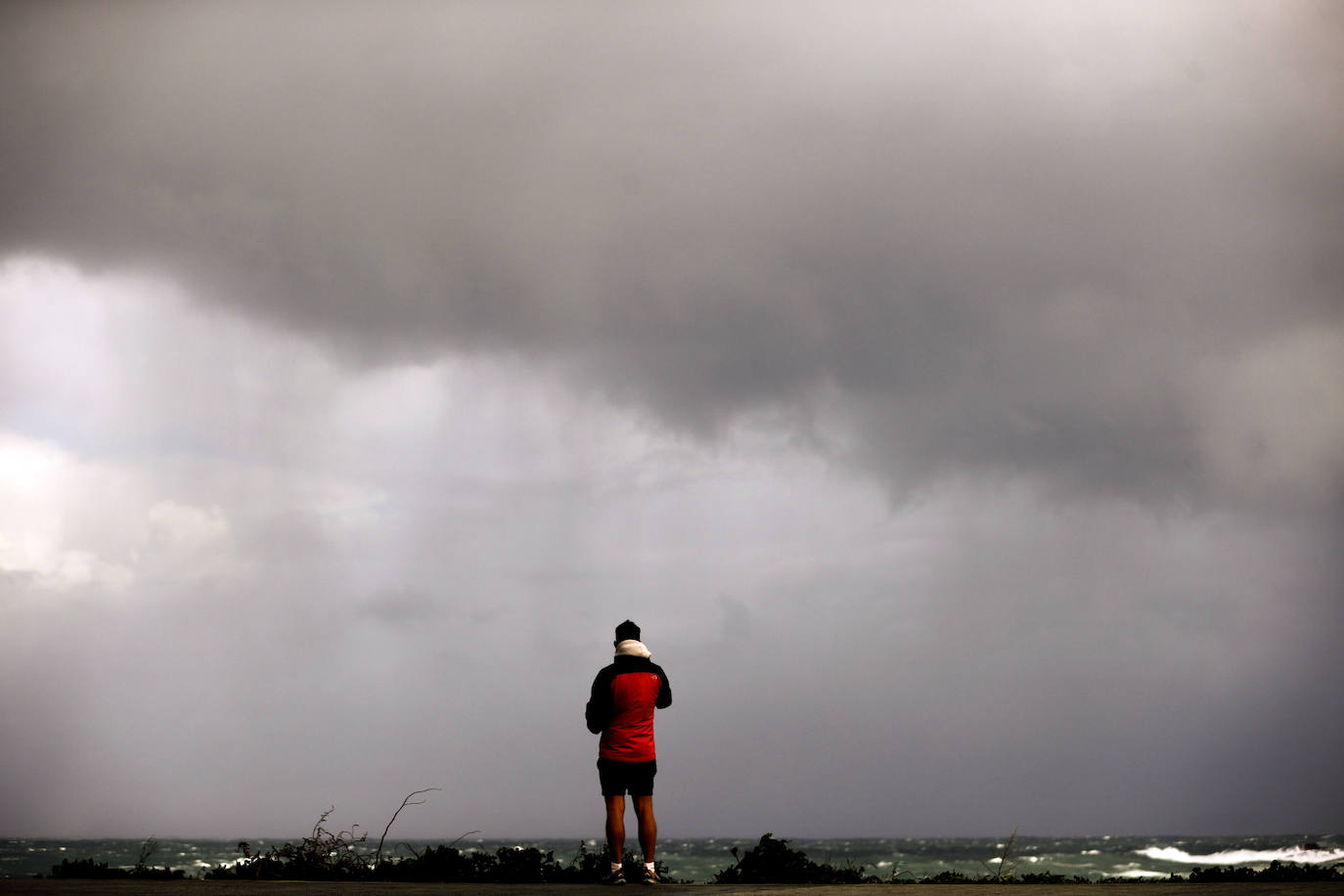 Un hombre toma fotografías del temporal en el paseo marítimo de Coruña