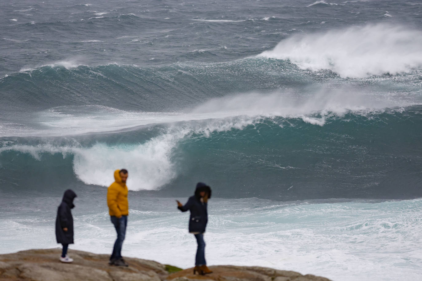 Turistas observan el oleaje en la costa de Muxía, Coruña