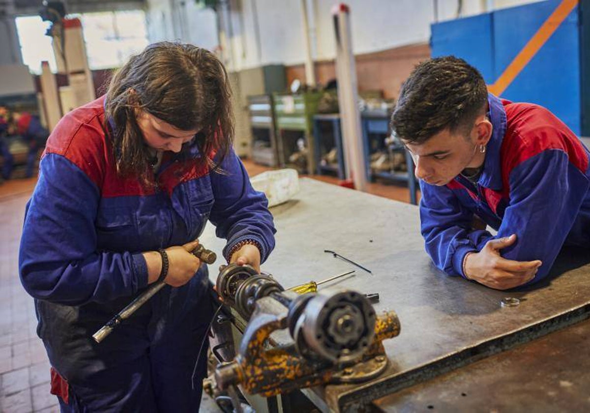 Varias personas aprenden mecánica en Orense, Galicia