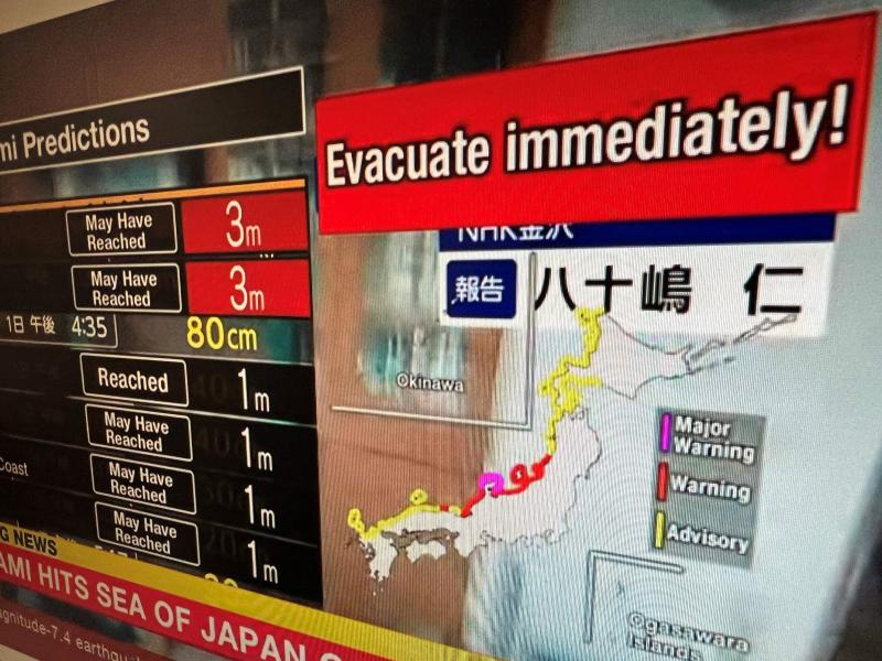 Mensaje de advertencia en una pantalla de una transmisión en vivo de NHK World pidiendo a la gente que evacue el área