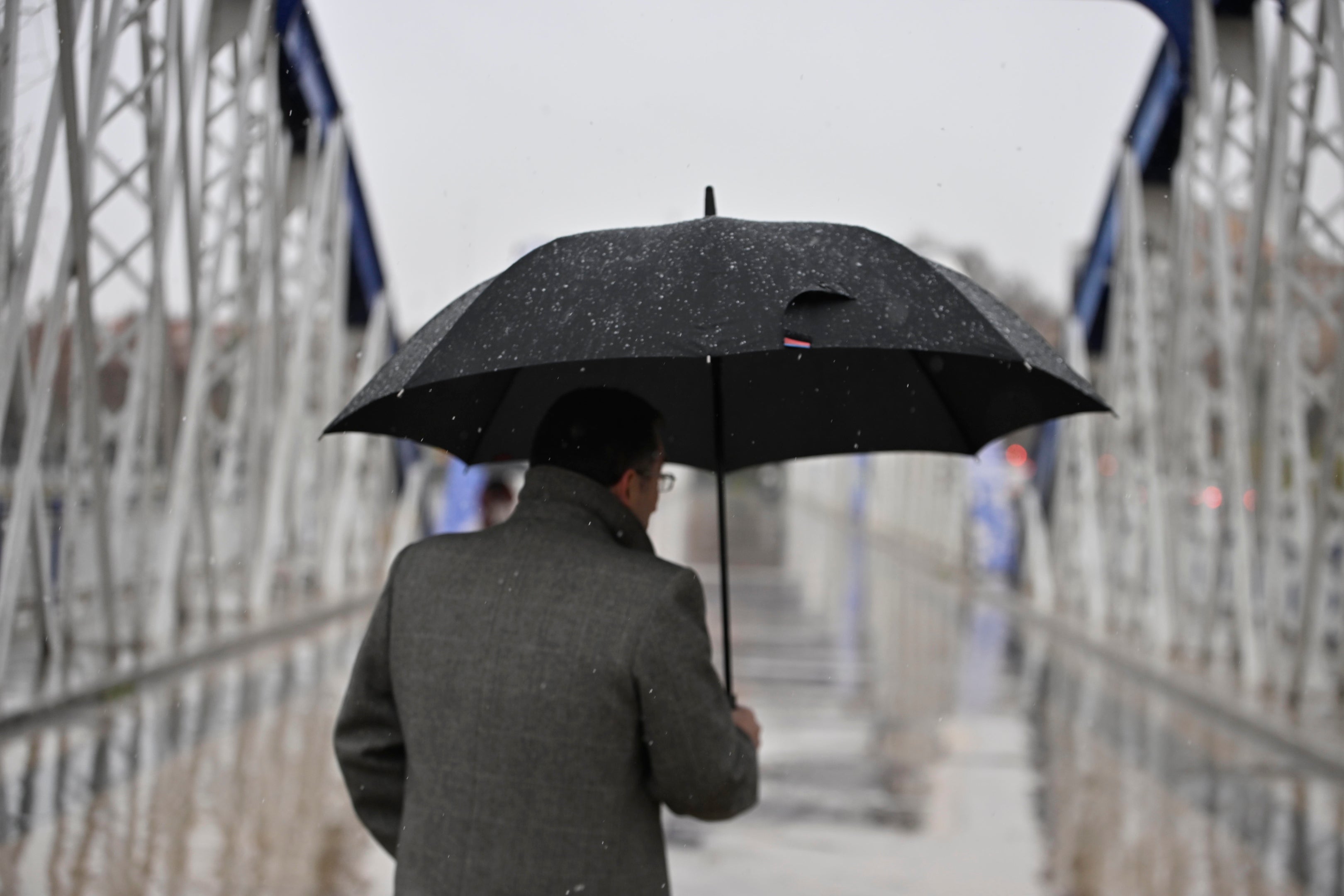 Una persona se cubre de la nieve con un paraguas