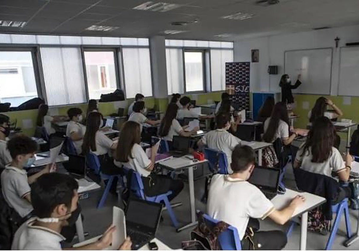 Un grupo de alumnos atienda a su profesora en clase