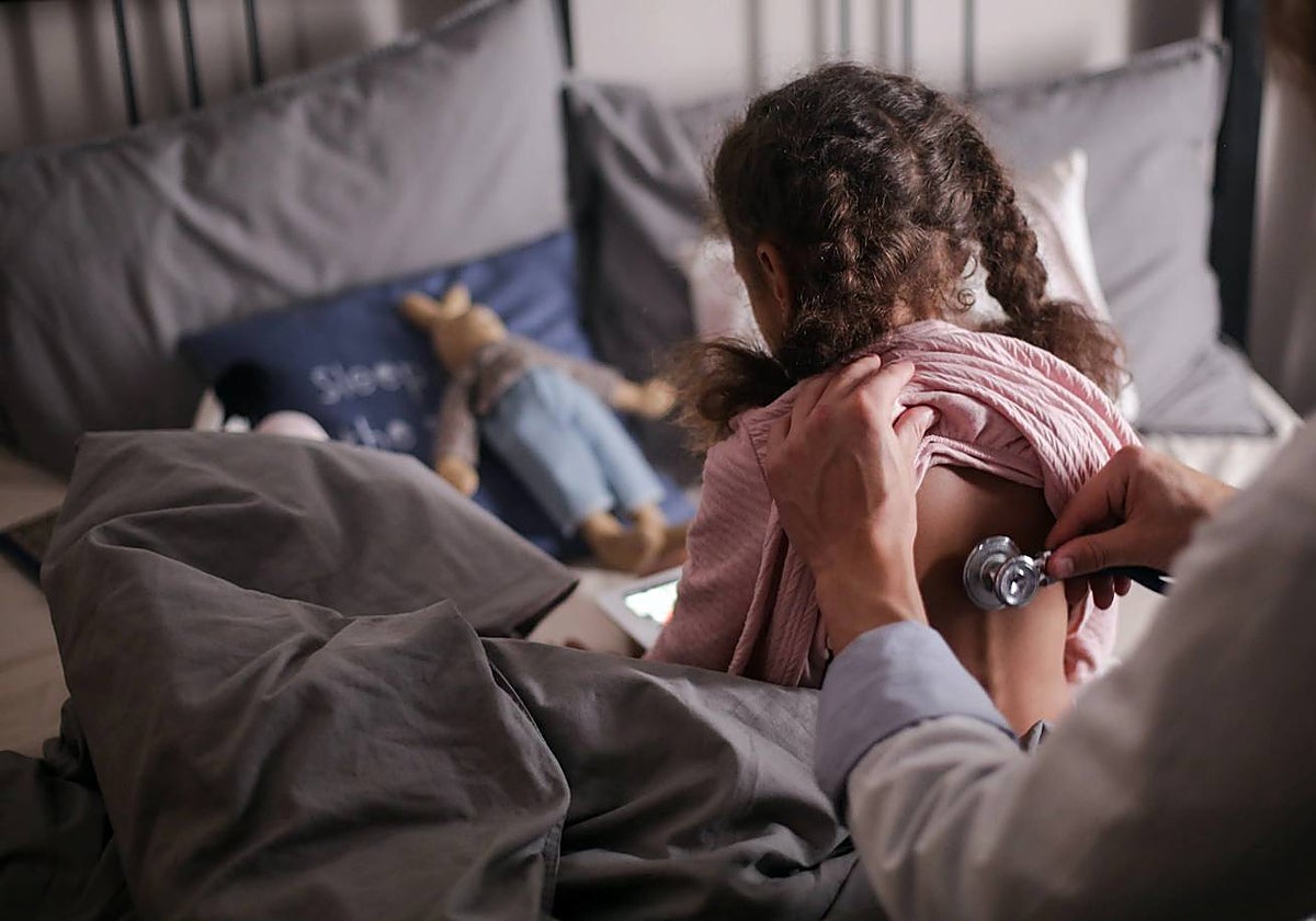 Un médico ausculta a una niña